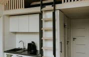 Modern tiny house with loft, ladder, and kitchenette at Camping Si-Es-An in the Netherlands.