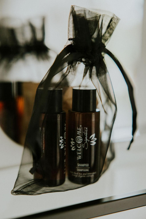 Bottiglie di shampoo marroni in sacchetto di rete nera al Tiny House XL presso Camping Si-Es-An, Paesi Bassi.