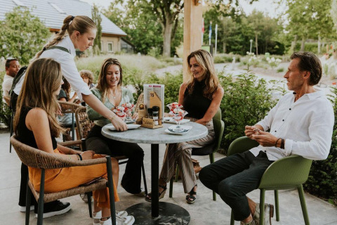 Gruppo gusta dessert all’aperto a Tiny house XL al Camping Si-Es-An nei Paesi Bassi.