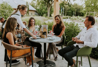 Gruppe genießt Desserts im Freien am Tiny house XL auf Camping Si-Es-An in den Niederlanden.