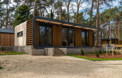 Modus Wellness lodge i Hoge Kempen, Belgien, moderne arkitektur omgivet af skov og natur.