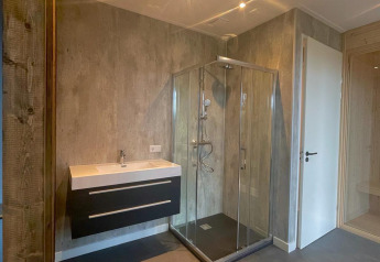 Salle de bain moderne au Modus Wellness, Hoge Kempen, Belgique avec douche en verre et lavabo mural.