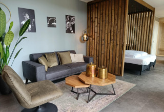 Moderne lodge zithoek bij Modus Wellness in Hoge Kempen, België, met houten accenten en stijlvolle meubels.