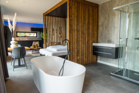 Moderne lodge bij Modus Wellness, Hoge Kempen, België, met vrijstaand bad en luxueuze inrichting.