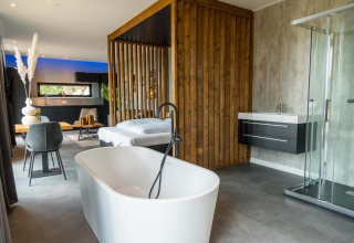 Moderne lodge bij Modus Wellness, Hoge Kempen, België, met vrijstaand bad en luxueuze inrichting.