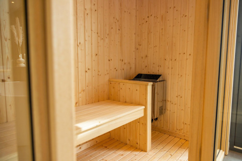 Binnenzicht van een moderne houten sauna in Modus Wellness te Hoge Kempen, België, met zitbank.
