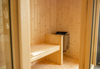 Interieur van een moderne houten sauna bij Modus Wellness in Hoge Kempen, België, met zicht op bank.