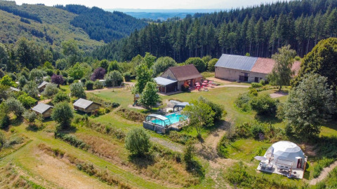 Vista aerea di un glamping con piscina, foresta e fattorie vicino a Châtel-Montagne, Auvergne-Rhône-Alpes, Francia.