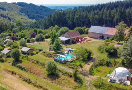 Vista aérea de un glamping con piscina, naturaleza y cabañas cerca de Châtel-Montagne, Auvergne-Rhône-Alpes, Francia.