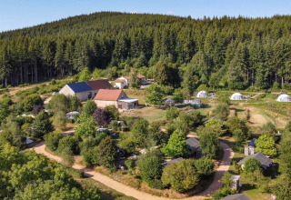 Vista aerea di Camping Domaine La Chabanne con tende, cabine e boschi in Alvernia-Rodano-Alpi, Francia.