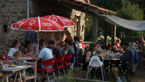People dining outdoors at Camping Domaine La Chabanne holiday park in Auvergne-Rhône-Alpes, France.