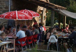 Persone che mangiano all'aperto al Camping Domaine La Chabanne, villaggio vacanze in Auvergne-Rhône-Alpes.