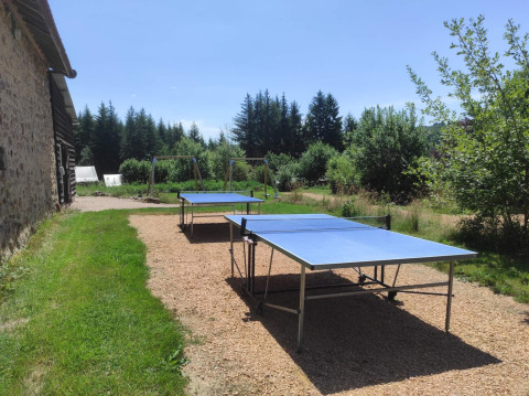 Mesas de tenis de mesa al aire libre y columpios en Camping Domaine La Chabanne en Auvergne-Rhône-Alpes, Francia.