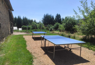 Outdoor table tennis tables and swings at Camping Domaine La Chabanne in scenic Auvergne-Rhône-Alpes, France.