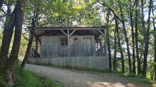 Cabaña de madera en una colina rodeada de árboles en Eco domaine Le Camp, Occitania, Francia.