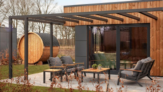 Moderne terras met tuinmeubels en houten sauna bij Holiday villa Amalia op Hofparken De Bergvennen, Nederland.