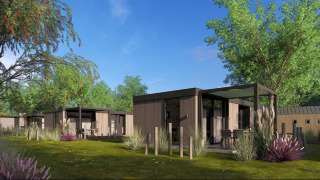 Moderne Lodges im Batenburgh Deluxe im Veluwepark de Bosgraaf, umgeben von viel Grün und Bäumen.