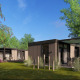 Moderne hytter ved Batenburgh Deluxe på Veluwepark de Bosgraaf, omgivet af grønne træer og blå himmel.