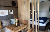 Modern tiny house interior at Kohnenhof in Luxembourg, featuring a dining area and cozy bed space.