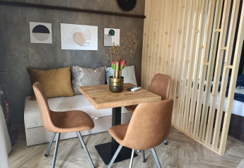 Moderne og hyggelig spiseplads i Tiny House på Kohnenhof i Luxembourg med læderstole og vægdekoration.