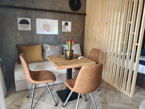 Acogedor comedor en el Tiny House de Kohnenhof, Luxemburgo, con sillas de cuero y decoración mural.