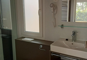Modernes Badezimmer in einem Tiny House am Kohnenhof in Luxemburg mit WC, Waschbecken und Fenster.