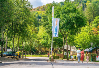 Famille se promenant près du Tiny House à Kohnenhof, Luxembourg, dans le parc EuroParcs, verdure luxuriante.