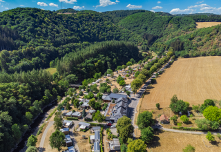 Vista aerea della Tiny House al Kohnenhof in Lussemburgo, circondata da boschi e campi aperti.