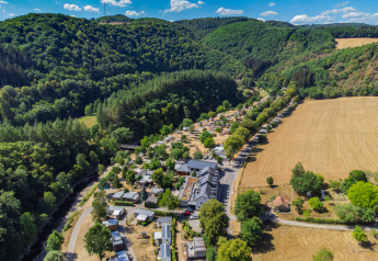 Luftfoto af Tiny House ved Kohnenhof i Luxembourg, omgivet af skove, bakker og åbne marker.