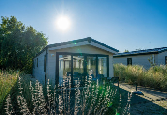 Lodge Velthorst al Poort van Zeeland nei Paesi Bassi, circondato da piante e prato in una giornata di sole.