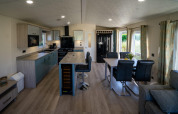 Modern kitchen and dining area inside a Velthorst lodge at Poort van Zeeland, featuring large windows and light decor.
