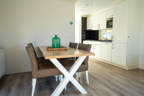 Comedor moderno y cocina en una cabaña Velthorst de Poort van Zeeland, Países Bajos, con muebles elegantes.