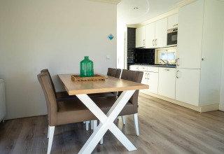 Modern dining area and kitchen at a Velthorst lodge in Poort van Zeeland, Netherlands, with stylish furnishings.