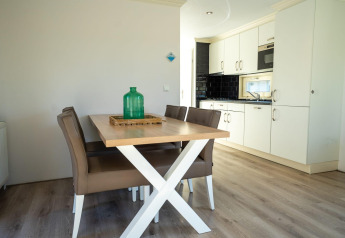 Salle à manger moderne et cuisine dans un lodge Velthorst à Poort van Zeeland, Pays-Bas, avec mobilier élégant.