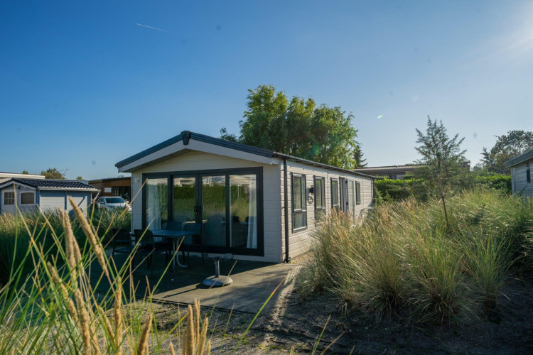 Lodge Velthorst en Poort van Zeeland, Países Bajos, rodeado de naturaleza bajo un cielo azul en un día soleado