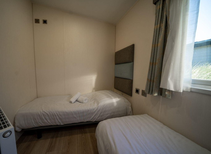 Dos camas individuales en una pequeña habitación de la Velthorst lodge en Poort van Zeeland, Países Bajos.