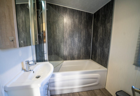 Modernes Badezimmer mit Badewanne, Glasdüse und Waschbecken in der Velthorst Lodge, Niederlande.