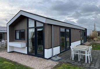 Modernes Velthorst-Lodge im Poort van Zeeland, Niederlande, mit Terrasse und Gartenmöbeln.