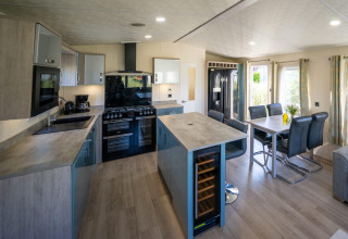Cocina moderna y comedor en una cabaña Velthorst en Poort van Zeeland, Países Bajos, con mucha luz natural.