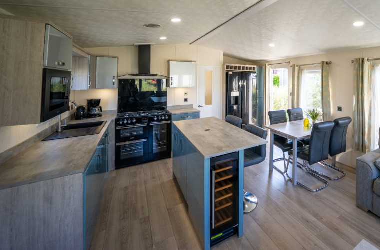 Cocina moderna y comedor en una cabaña Velthorst en Poort van Zeeland, Países Bajos, con mucha luz natural.
