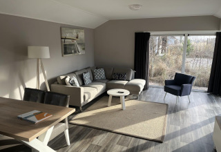 Helles, modernes Wohnzimmer in der Velthorst Lodge, Poort van Zeeland, Niederlande mit großen Fenstern.