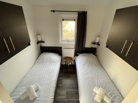 Dos camas individuales en una pequeña habitación de la Velthorst lodge en Poort van Zeeland, Países Bajos.