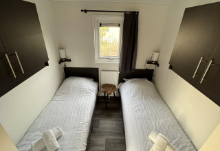Dos camas individuales en una pequeña habitación de la Velthorst lodge en Poort van Zeeland, Países Bajos.