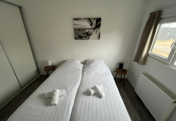 Schlafzimmer in der Velthorst-Lodge in Poort van Zeeland, Niederlande, mit zwei Einzelbetten.