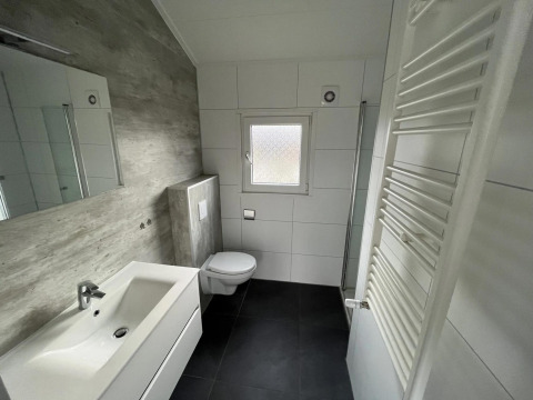 Baño moderno en la cabaña Velthorst de Poort van Zeeland, Países Bajos, con azulejos blancos y diseño limpio.