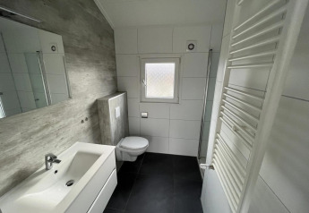 Bagno moderno al lodge Velthorst presso Poort van Zeeland, Paesi Bassi, con piastrelle bianche e arredo essenziale.