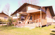 Tienda safari Ranger en Camping Vossenberg, Países Bajos, con terraza de madera y bancos de picnic.