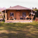 Safaritent Cottage bij Camping Vossenberg in Nederland, met ligstoelen en picknicktafels op het grasveld.