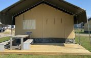Tienda safari en Holiday Park Duinhoeve, Países Bajos, con terraza de madera y banco de picnic al aire libre.