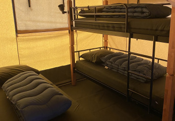 Intérieur d'une tente safari au Holiday Park Duinhoeve aux Pays-Bas, avec lits superposés et lit simple.